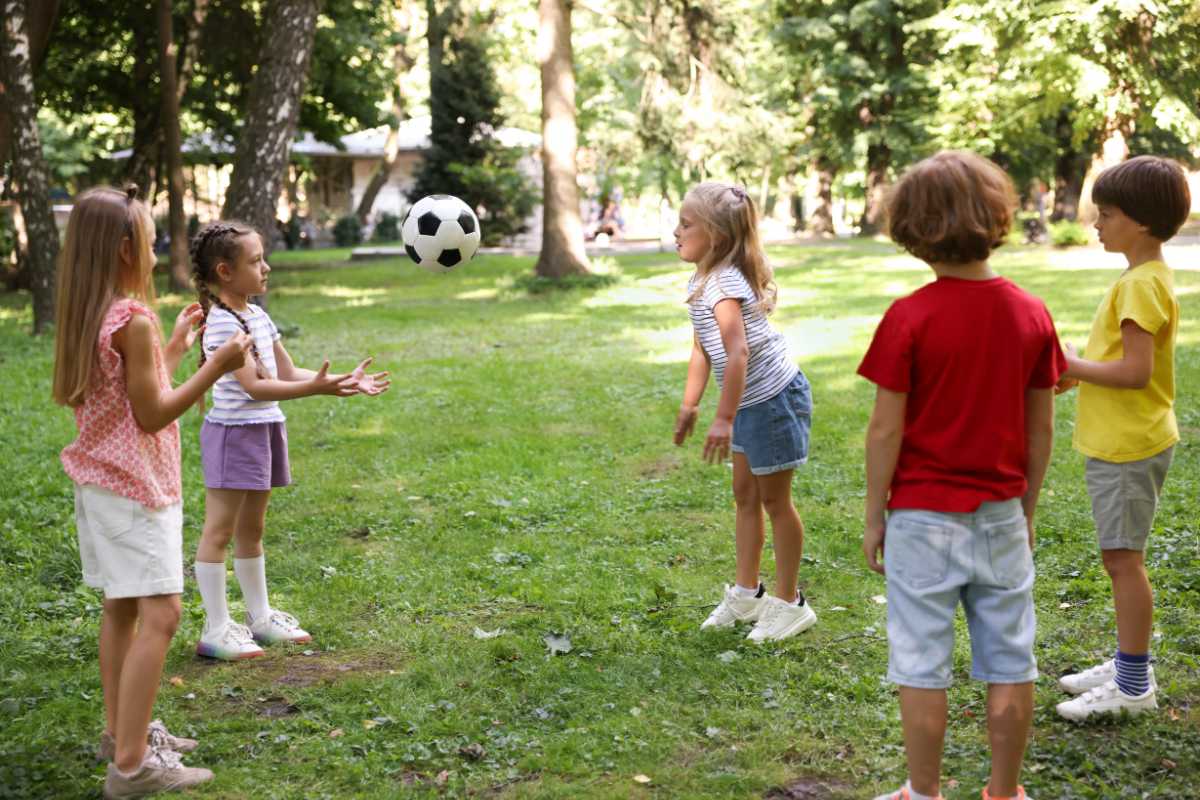 Bambini che giocano in un parco di Gerace, con vista sul borgo medievale sullo sfondo.