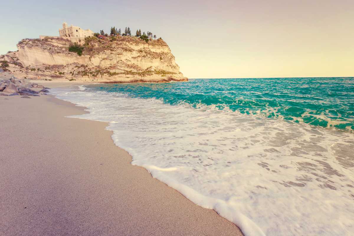Spiaggia di Tropea al tramonto con i turisti che godono della bellezza naturale