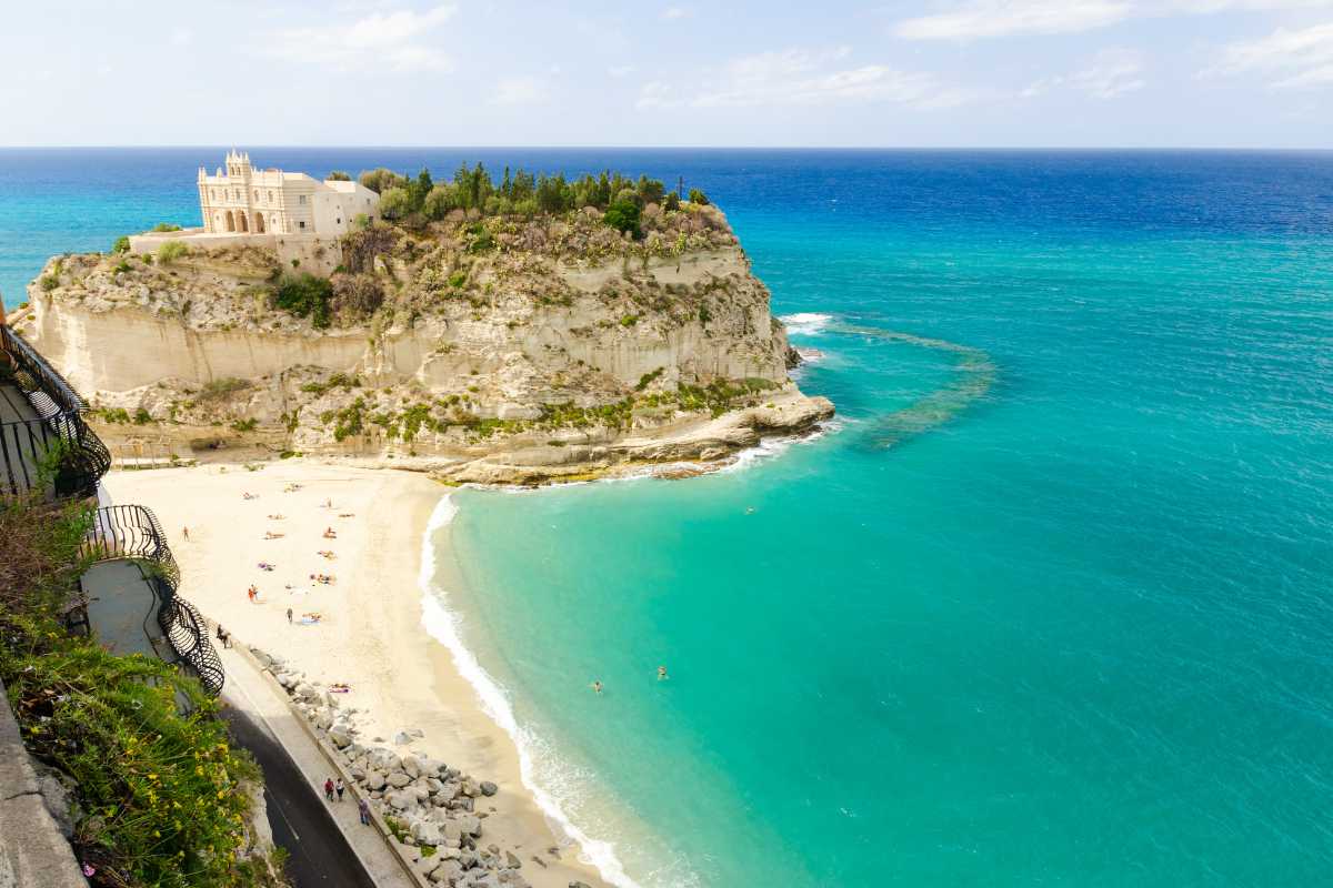Vista panoramica di Tropea con bambini in spiaggia, evidenziando le sue meravigliose spiagge bianche