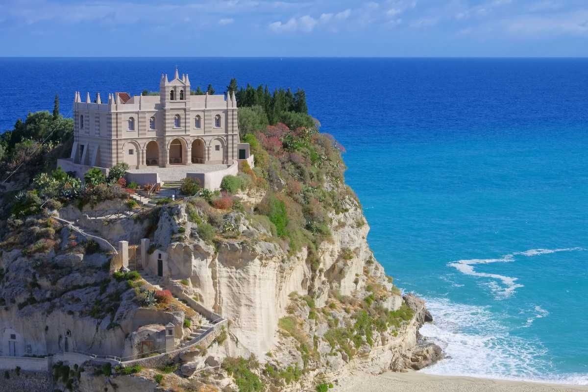 Panorama di Tropea con il mare cristallino e il Santuario di Santa Maria dell'Isola in primo piano